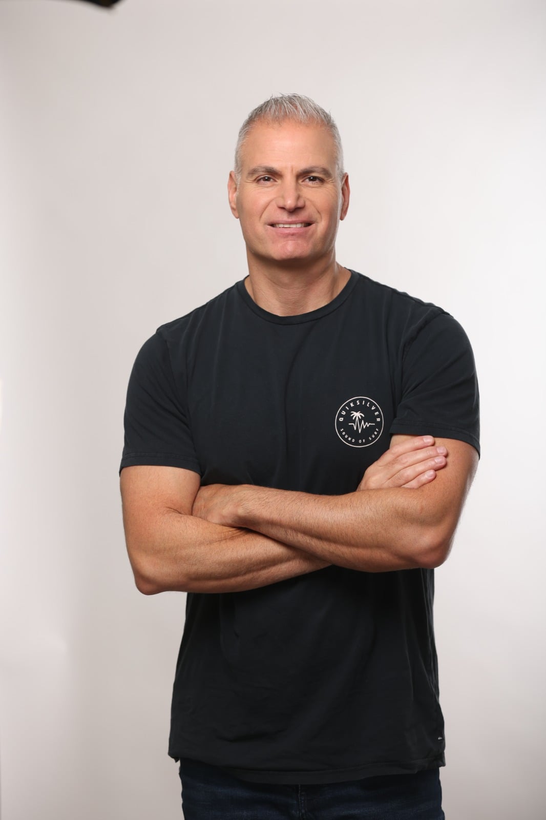 Man with crossed arms, wearing Quicksilver shirt. Variant 1.